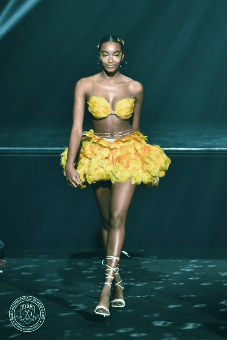 Femme défilant avec une tenue jaune en plume façon carnaval